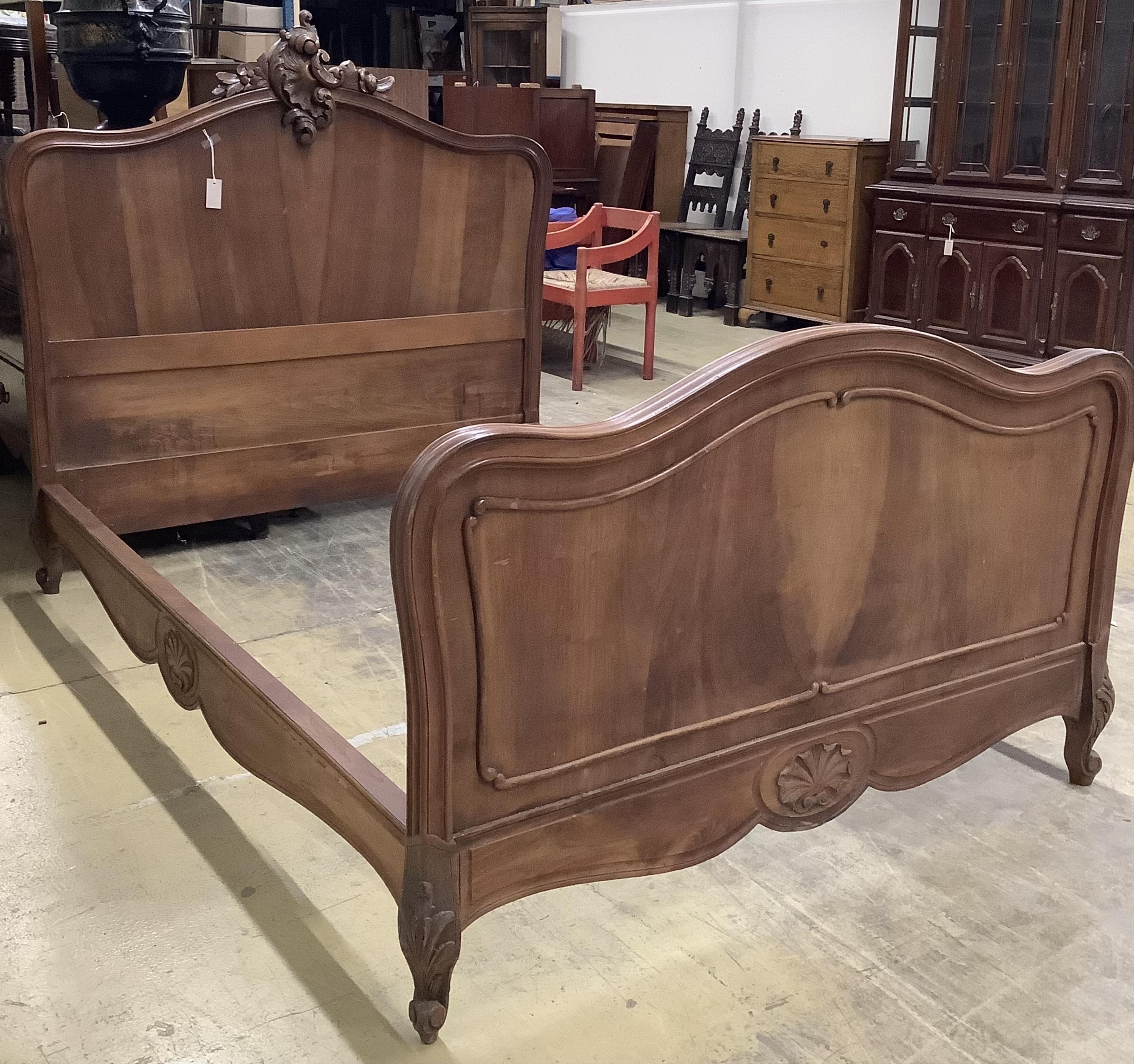 An early 20th century French walnut bedframe, width 140cm, length 199cm, height 142cm. Condition - fair